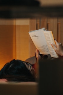 Reader holding the book while taking notes in a cozy home setting.