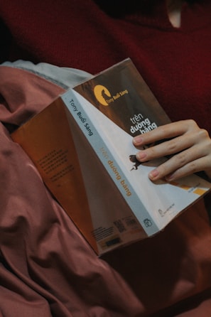 A man in a yellow chicken pajama holding a book with a sad expression.