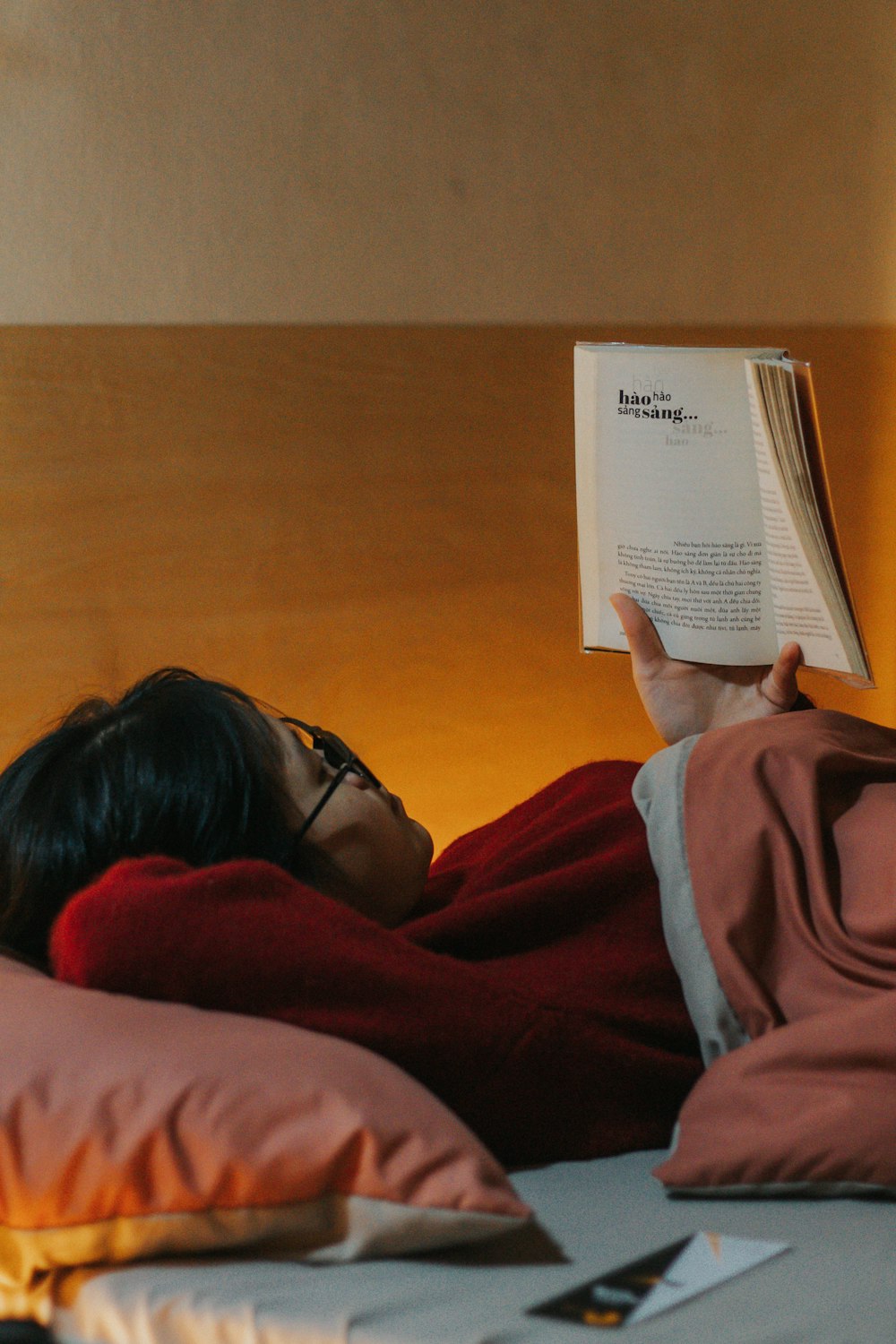 Donna in felpa con cappuccio rossa che legge il libro
