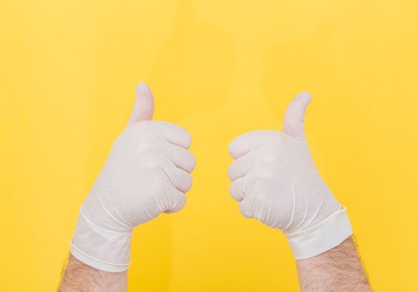 person in white long sleeve shirt doing thumbs up sign