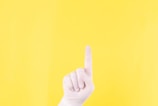 persons left hand doing thumbs up sign