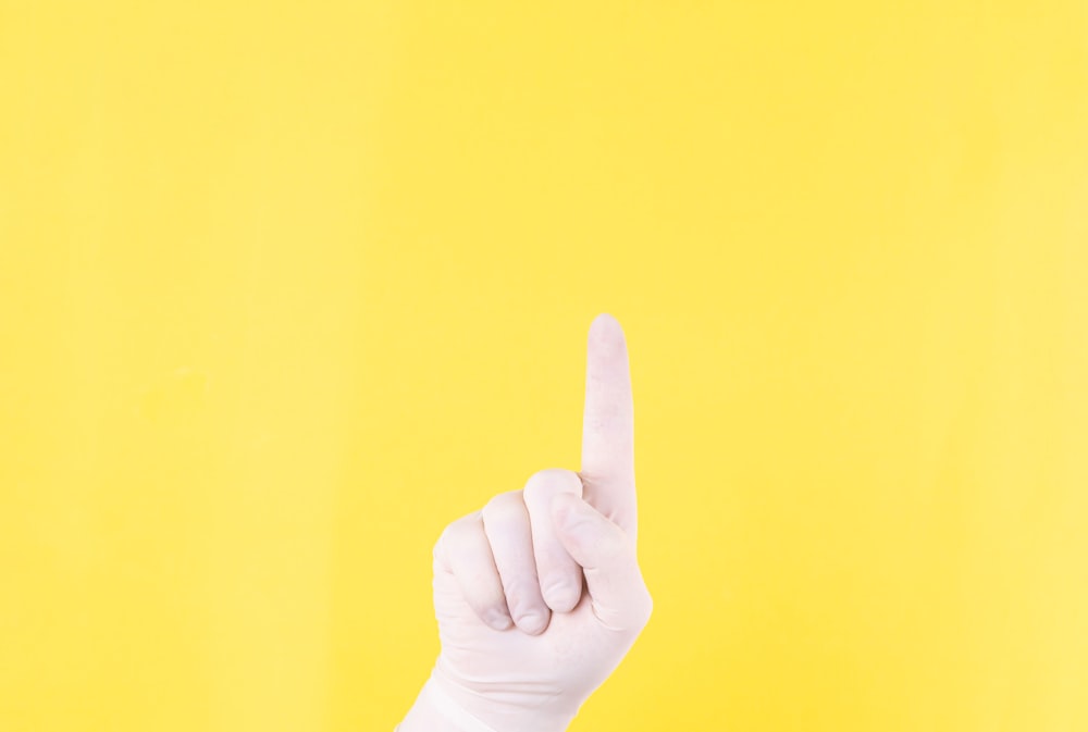 persons left hand doing thumbs up sign