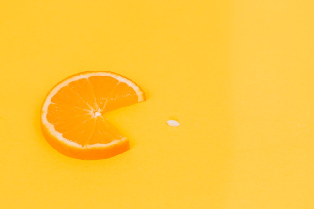 sliced orange fruit on yellow surface