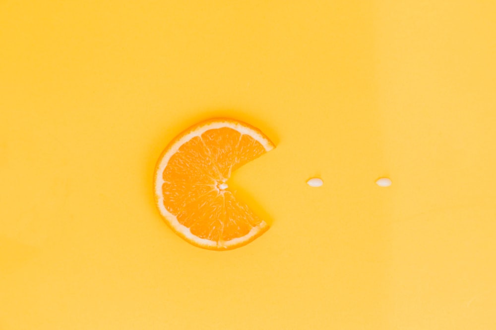 Fruto anaranjado sobre superficie amarilla