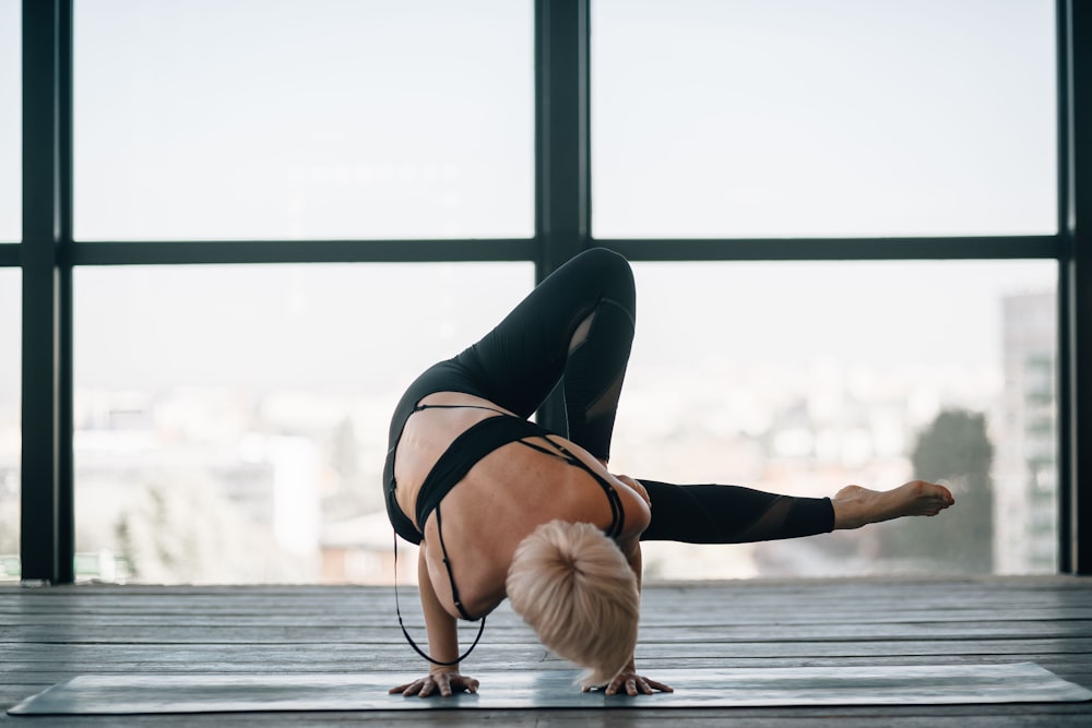 woman in black sports bra and black leggings doing yoga