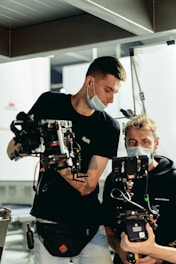man in black crew neck t-shirt holding black and white robot toy