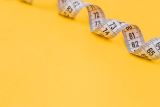 white tape measure on yellow surface