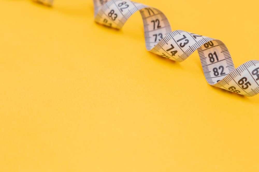 white tape measure on yellow surface