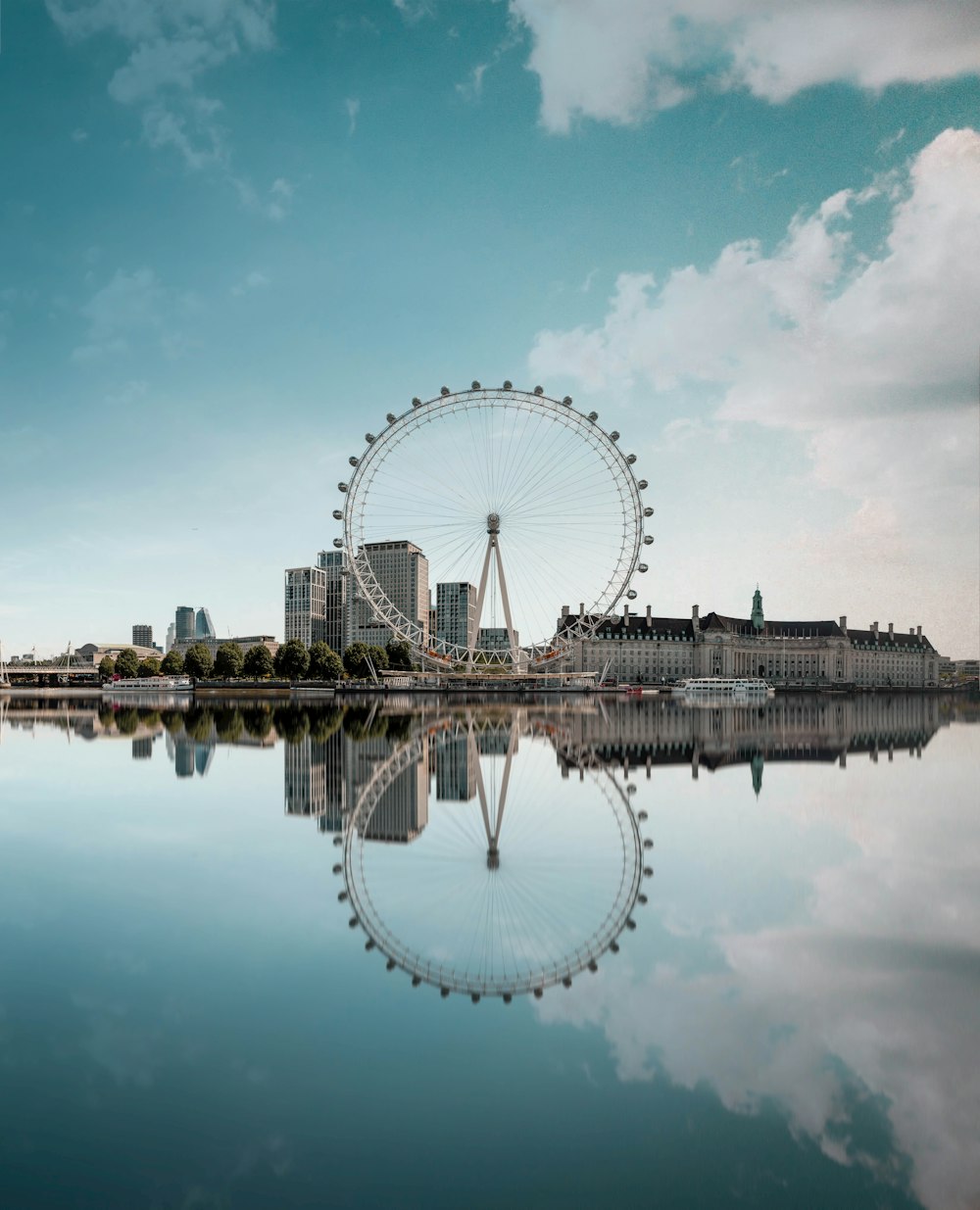 ferris wheel beside body of water under blue sky during daytime