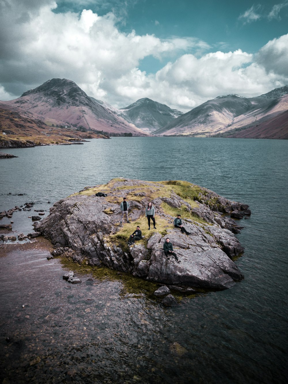 green and brown rock formation on body of water during daytime