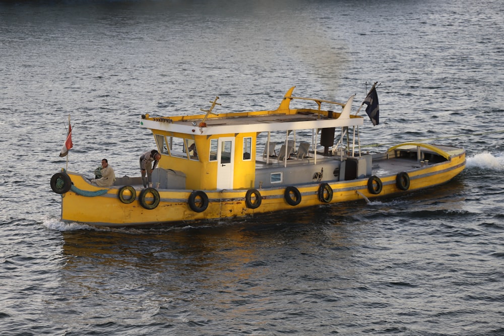 people riding yellow boat on water during daytime