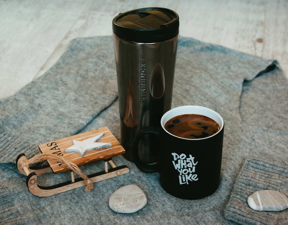 black and silver travel mug on brown wooden coaster