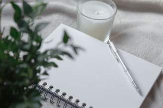 clear drinking glass with white liquid on white spiral notebook