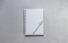 white notebook with pen on top