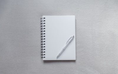 white notebook with pen on top