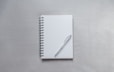white notebook with pen on top