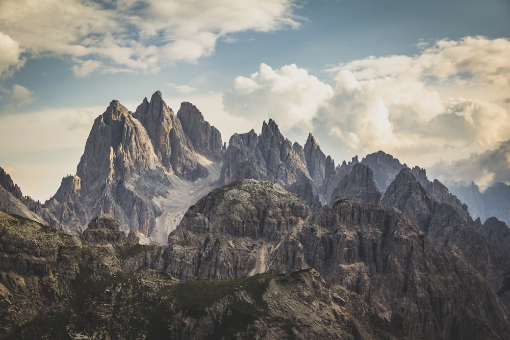 Montagna rocciosa marrone sotto nuvole bianche e cielo blu durante il giorno