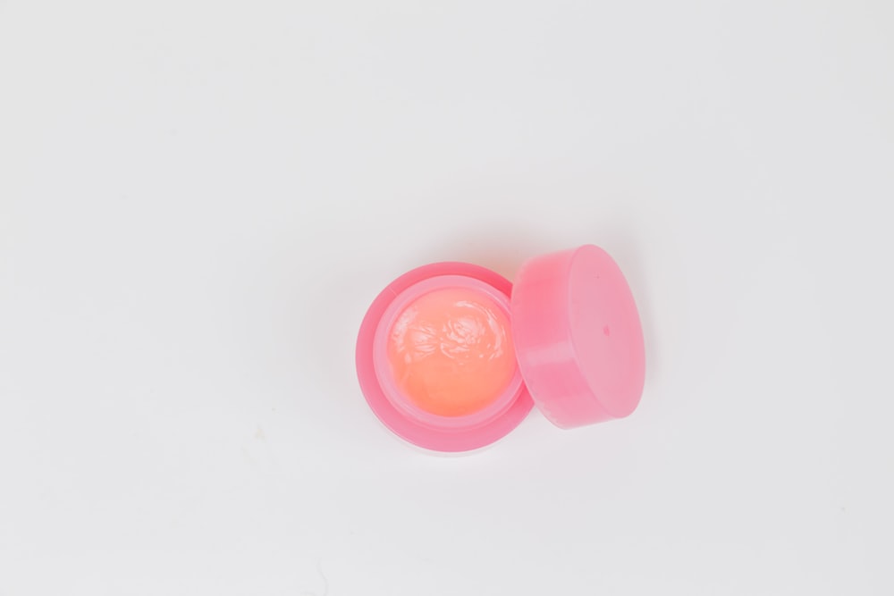 pink plastic round lid on white surface