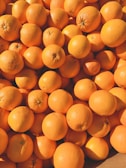 Bright oranges and pears piled high, showcasing their natural colors.
