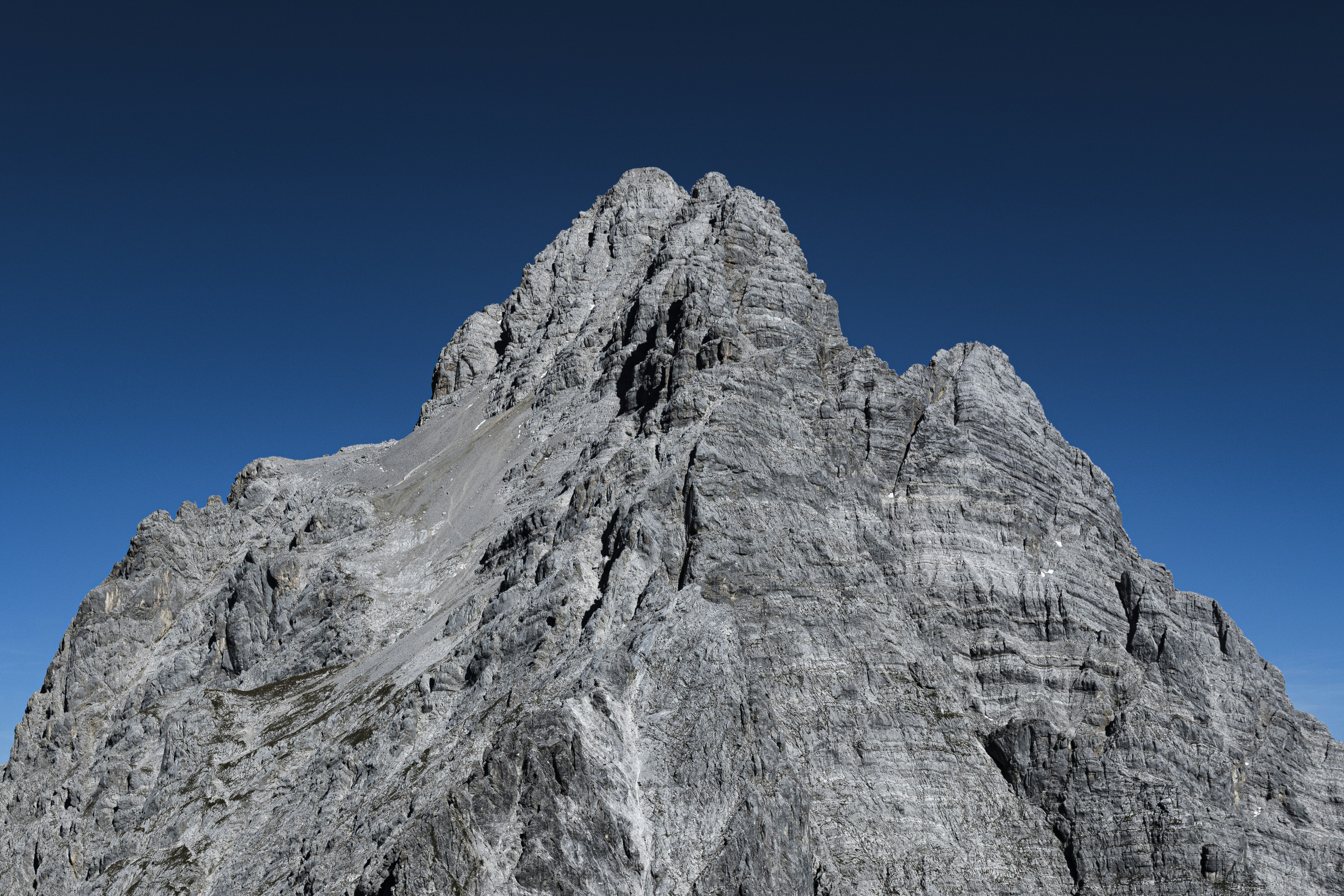 昼間の青空の下の灰色の岩山