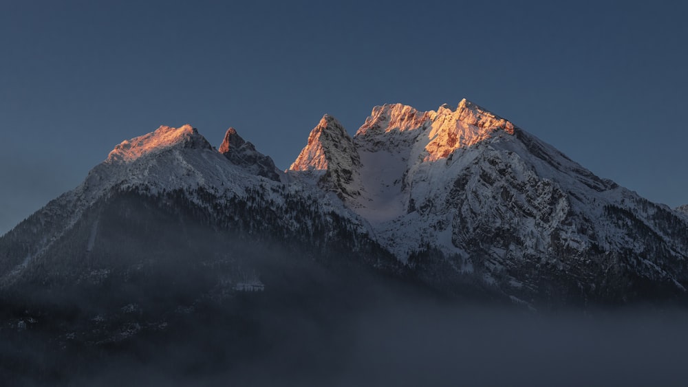 montanha coberta de neve sob o céu azul durante o dia