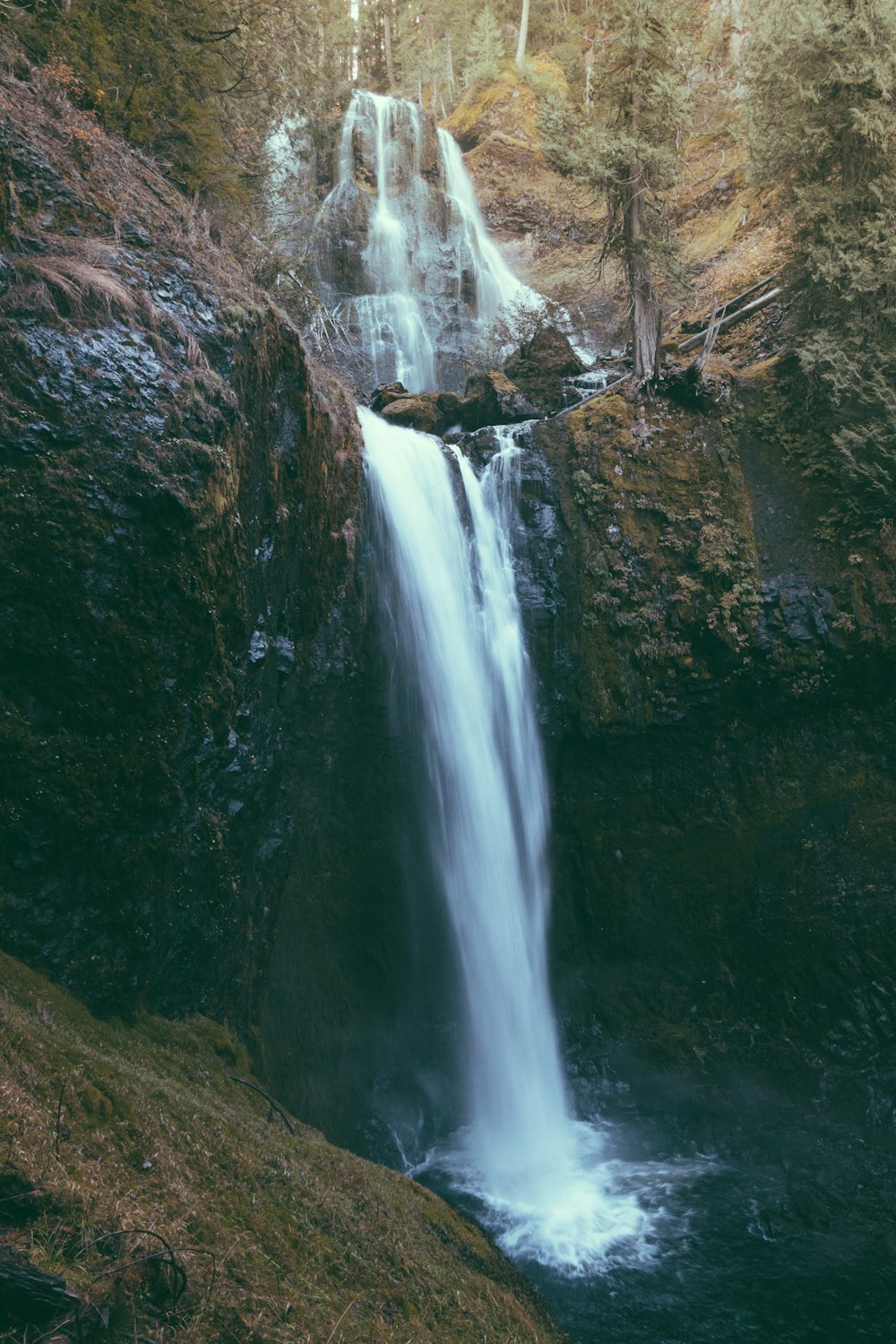 Cascate sulla montagna rocciosa marrone durante il giorno