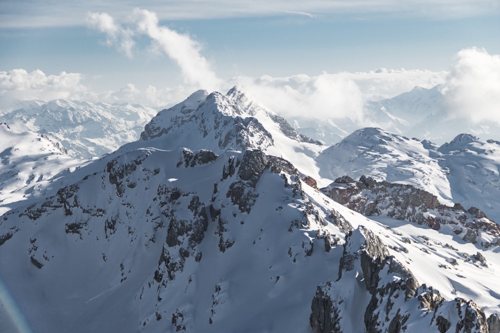 snow covered mountain under white clouds during daytime