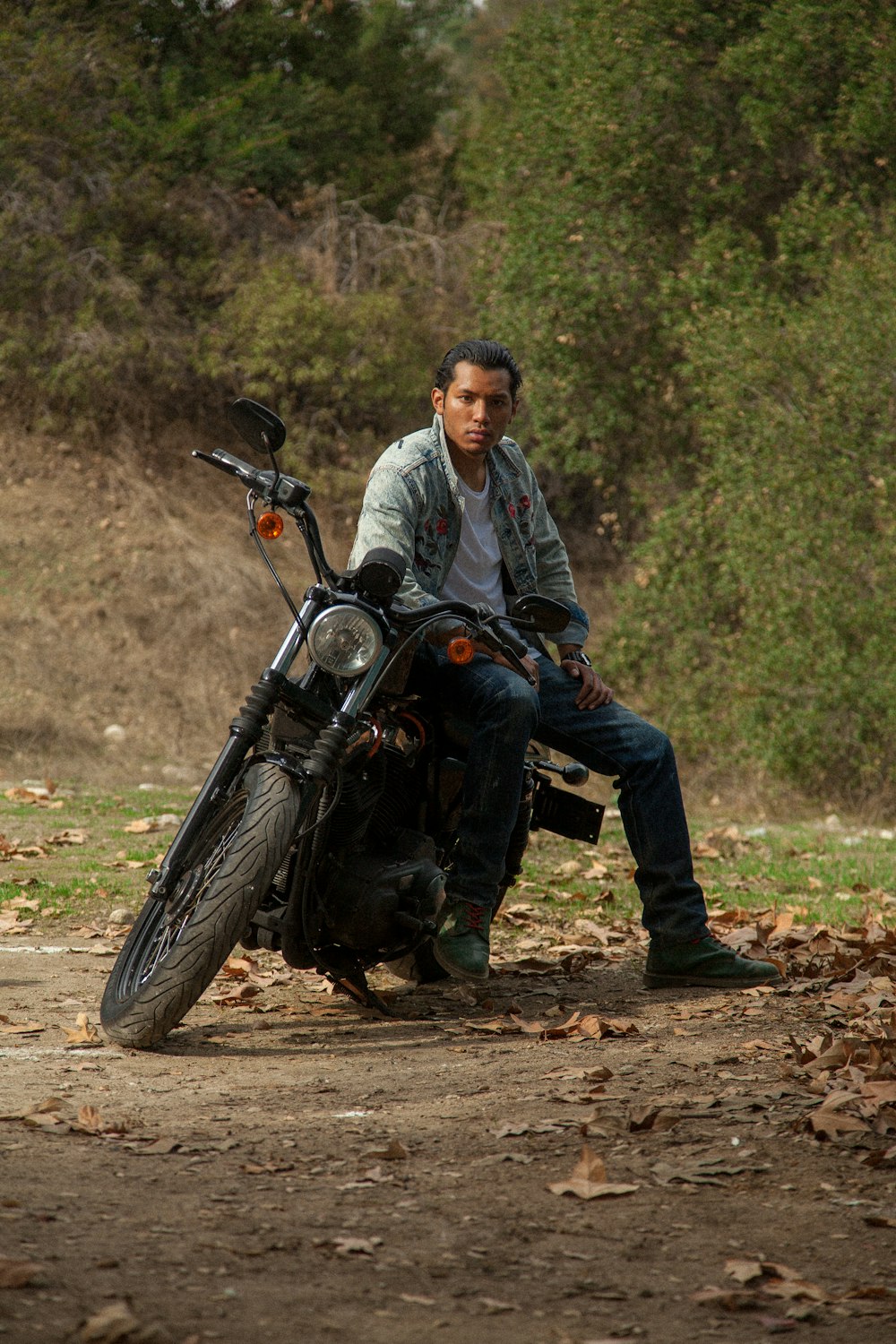 man in gray jacket and blue denim jeans riding black motorcycle during daytime
