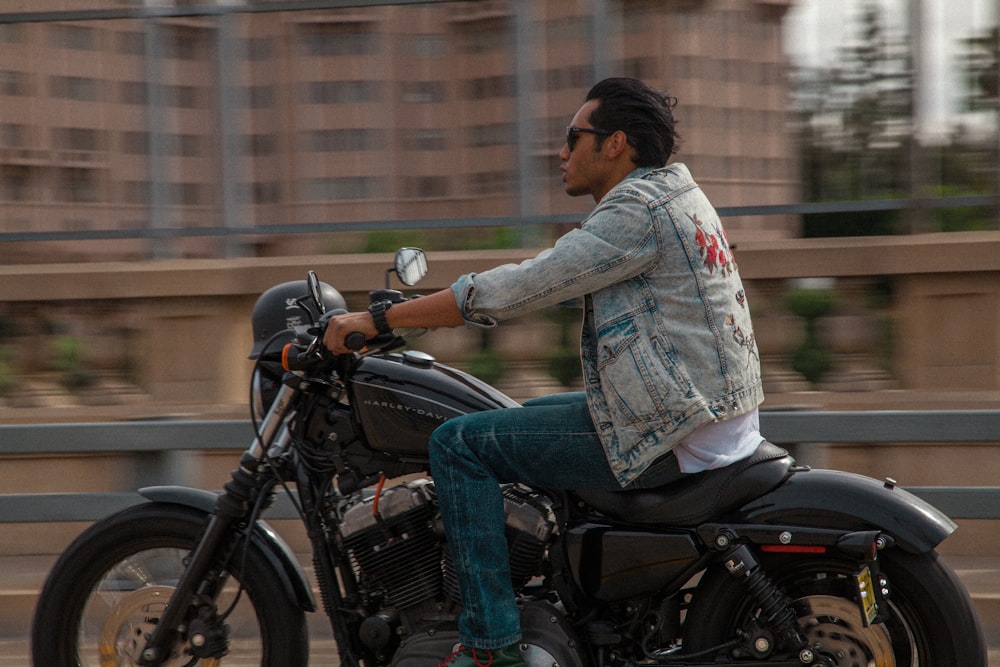 woman in blue denim jacket riding on black motorcycle during daytime