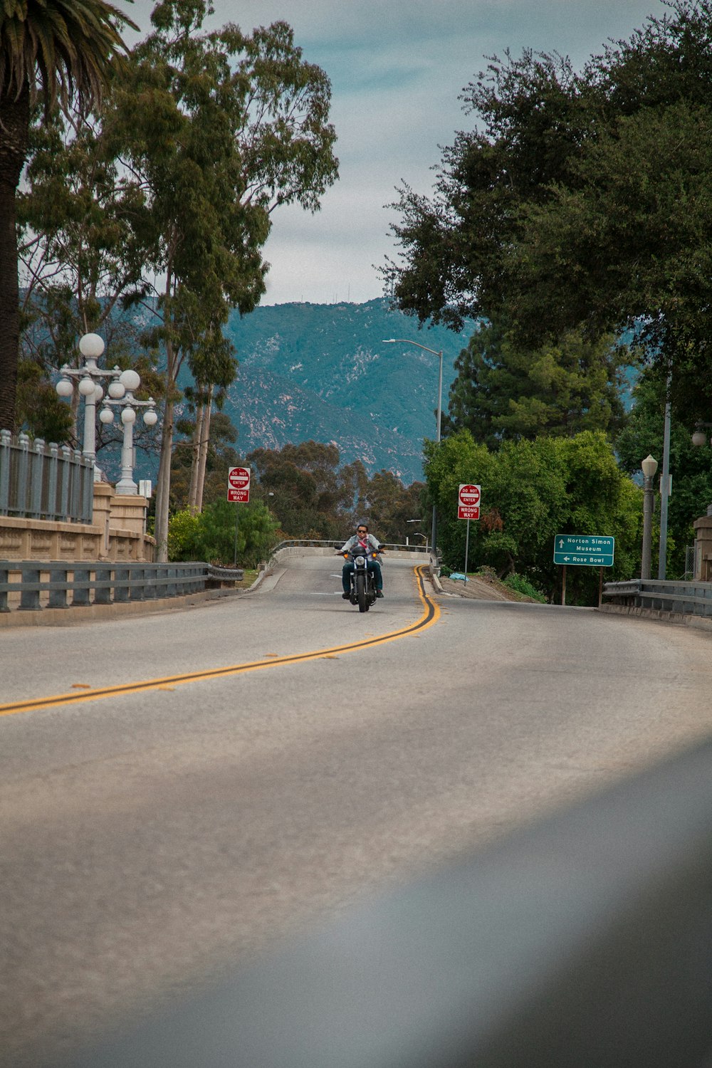 man riding motorcycle on road during daytime