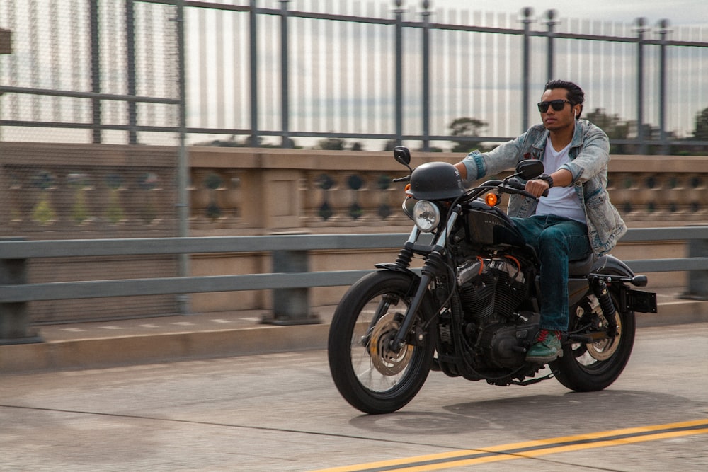 man in blue jacket riding black motorcycle