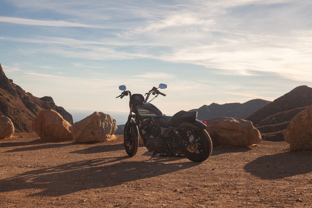 black motorcycle parked on brown dirt road during daytime