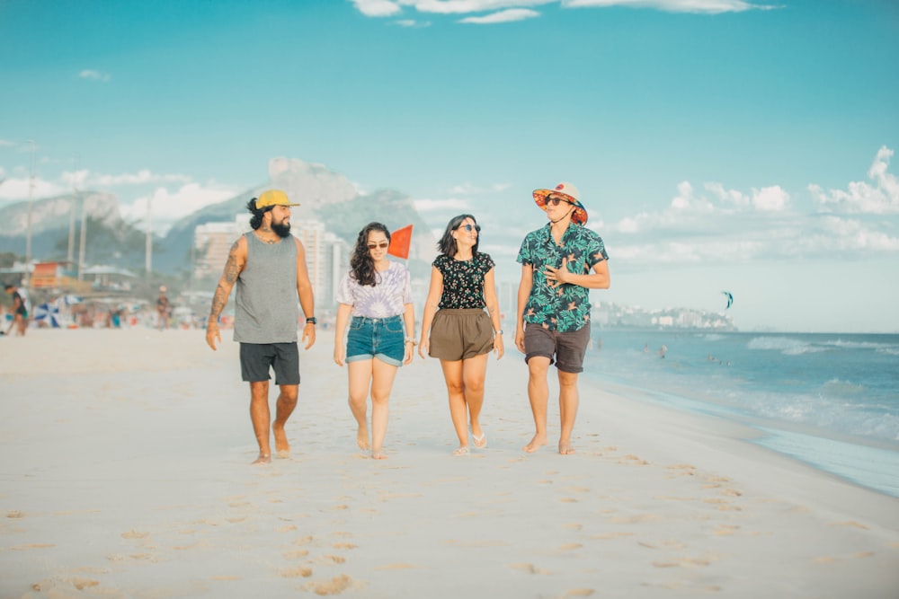 3 women standing on beach during daytime