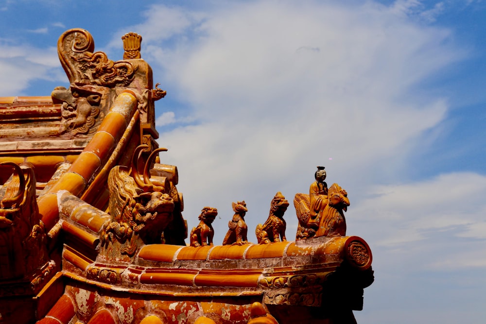 statue d’or sous un ciel nuageux pendant la journée