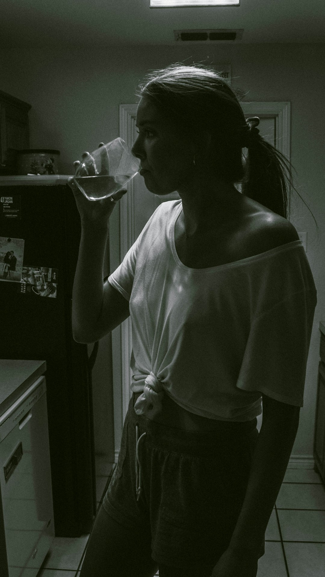 woman in white tank top drinking water