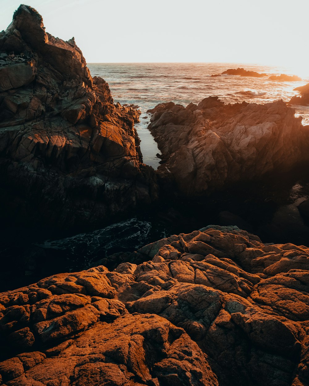 brown rock formation near body of water during daytime