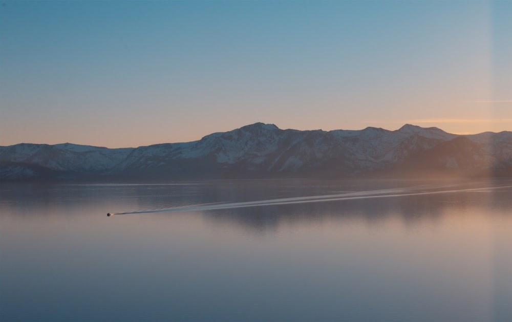 body of water near mountain during daytime