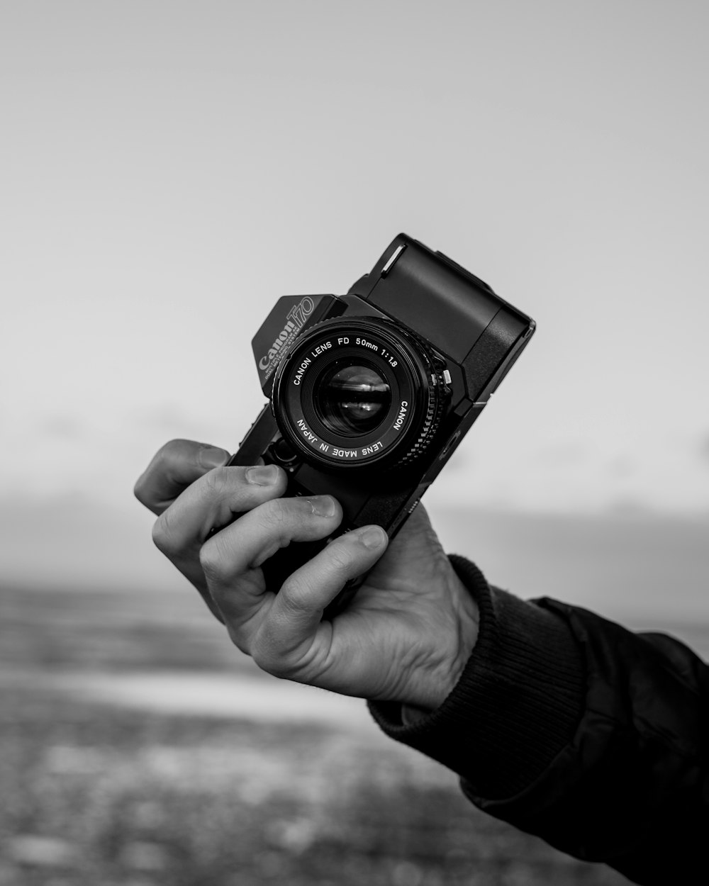 grayscale photo of person holding camera