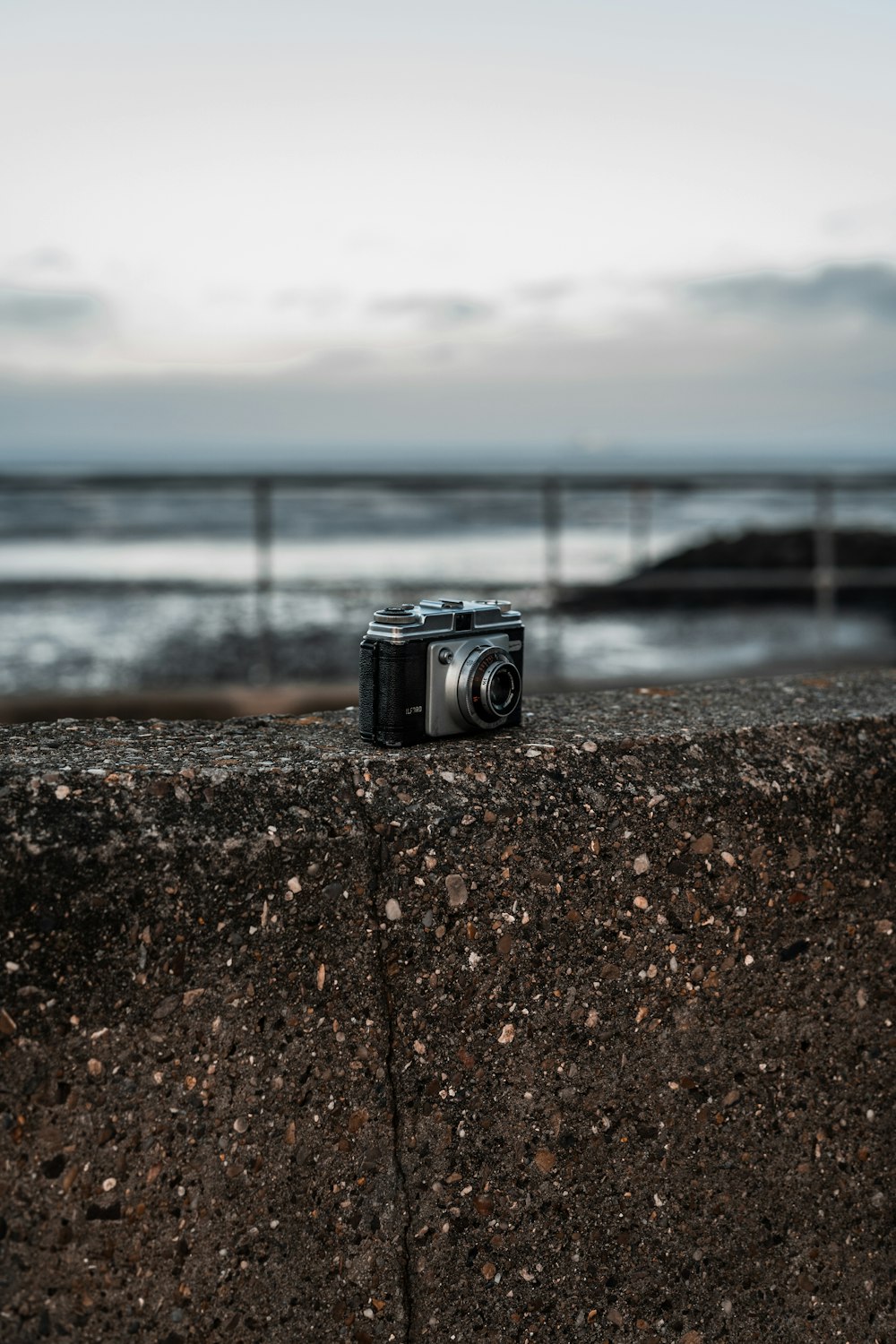black and silver camera on brown rocky shore during daytime