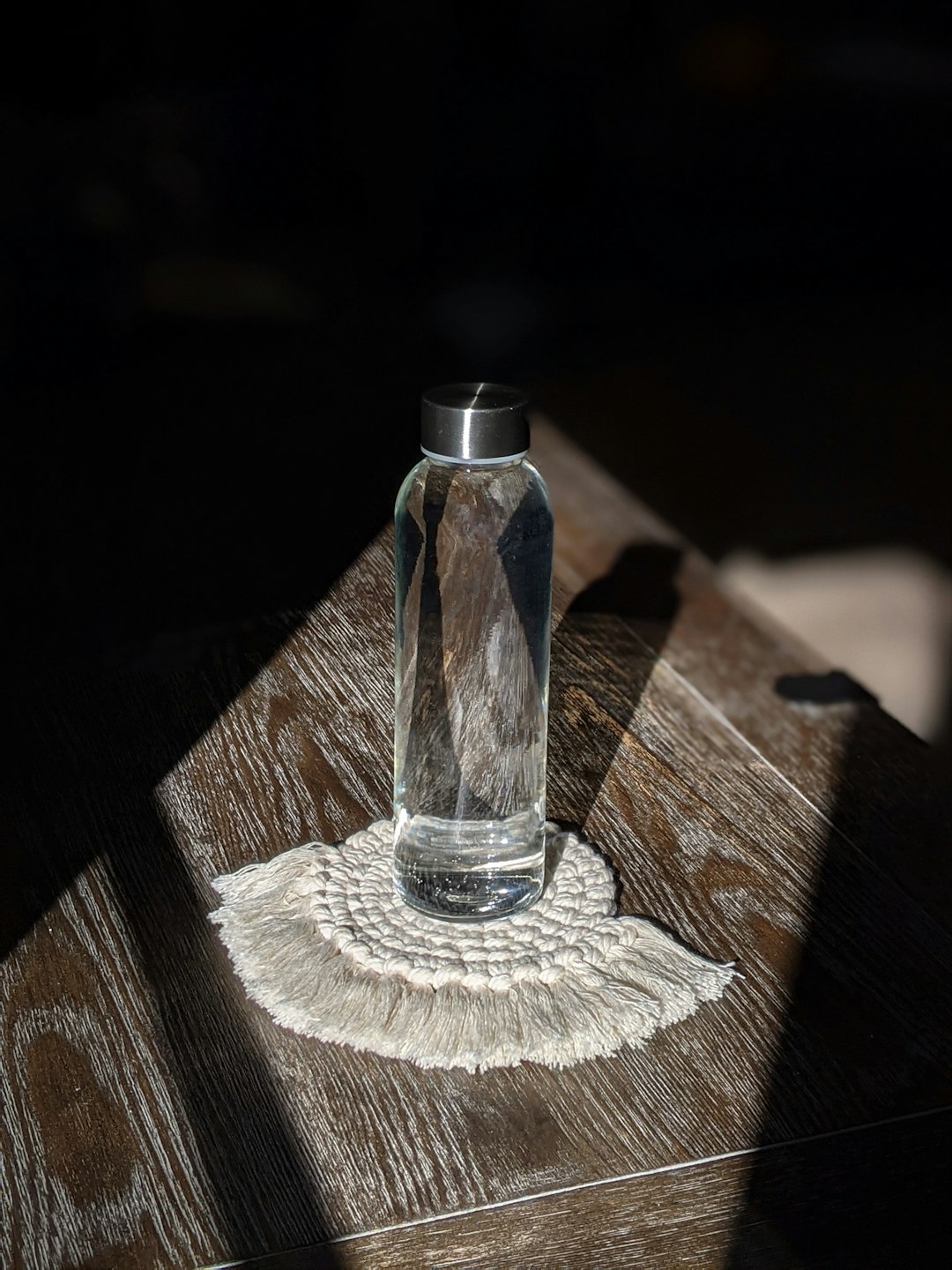 clear glass bottle on white textile