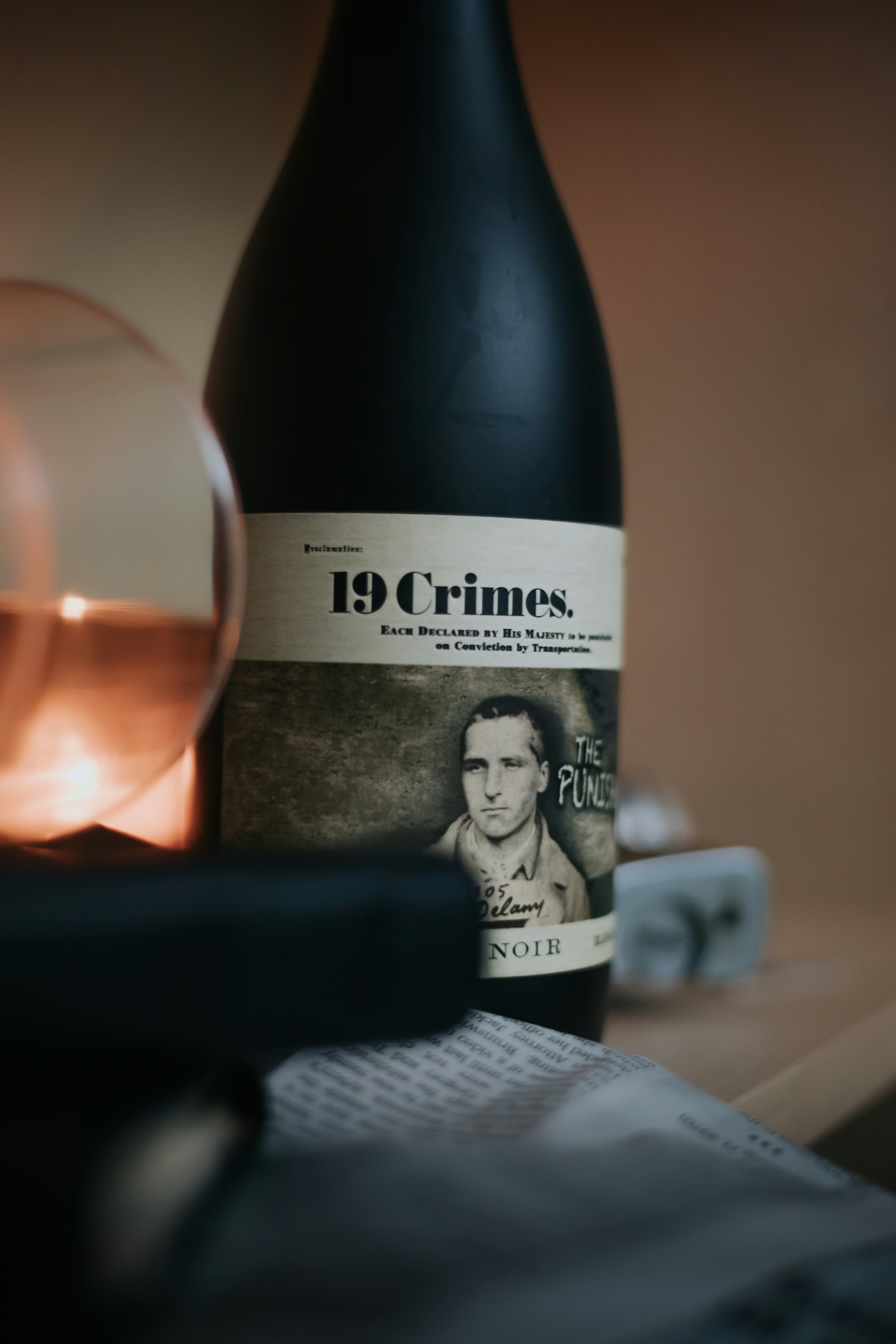 une bouteille de vin assise à côté d’une bougie