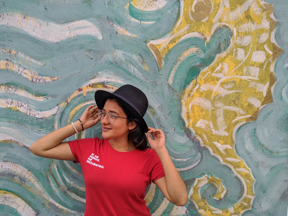 woman in red crew neck t-shirt wearing black hat