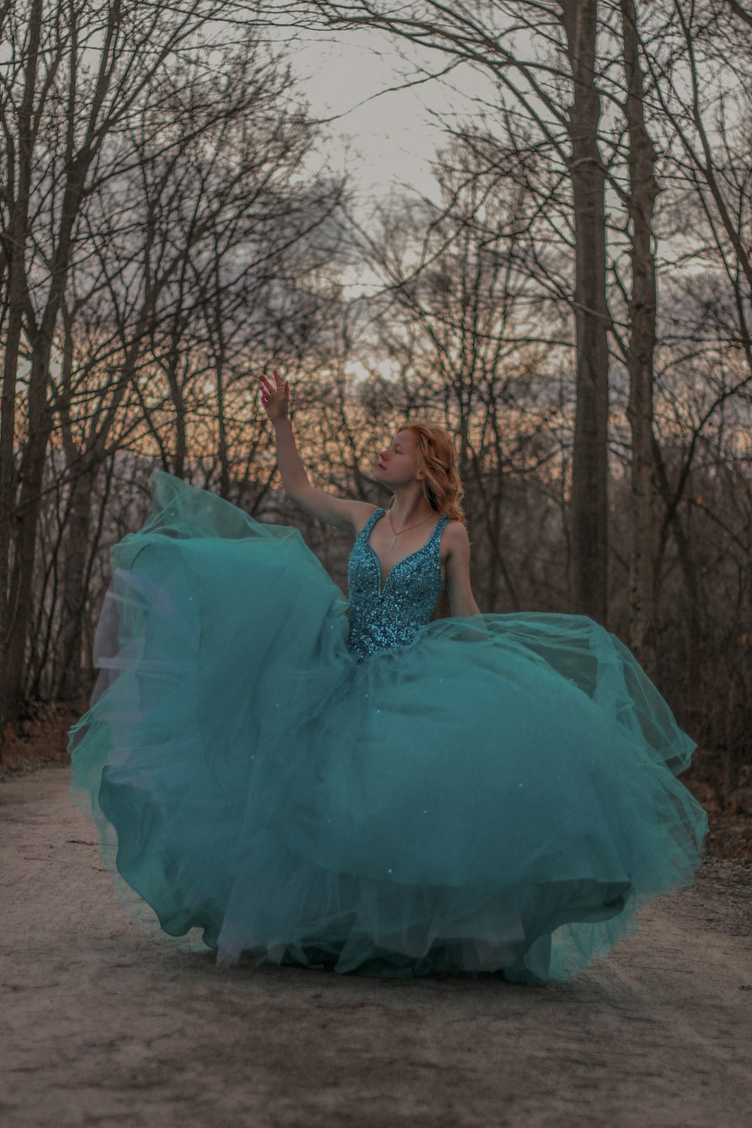 woman in blue tube dress sitting on brown tree branch during daytime