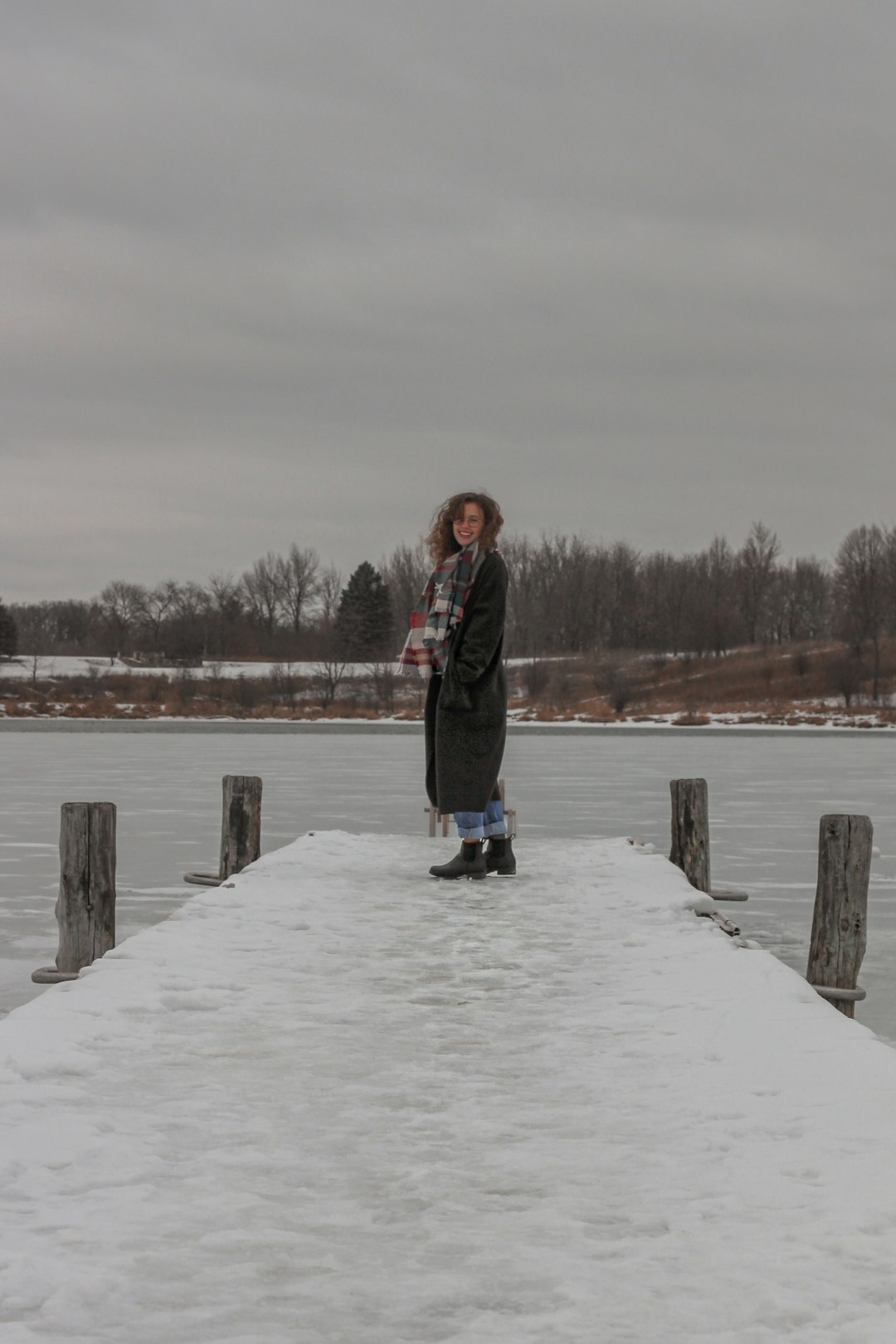 woman in black jacket standing on snow covered ground during daytime