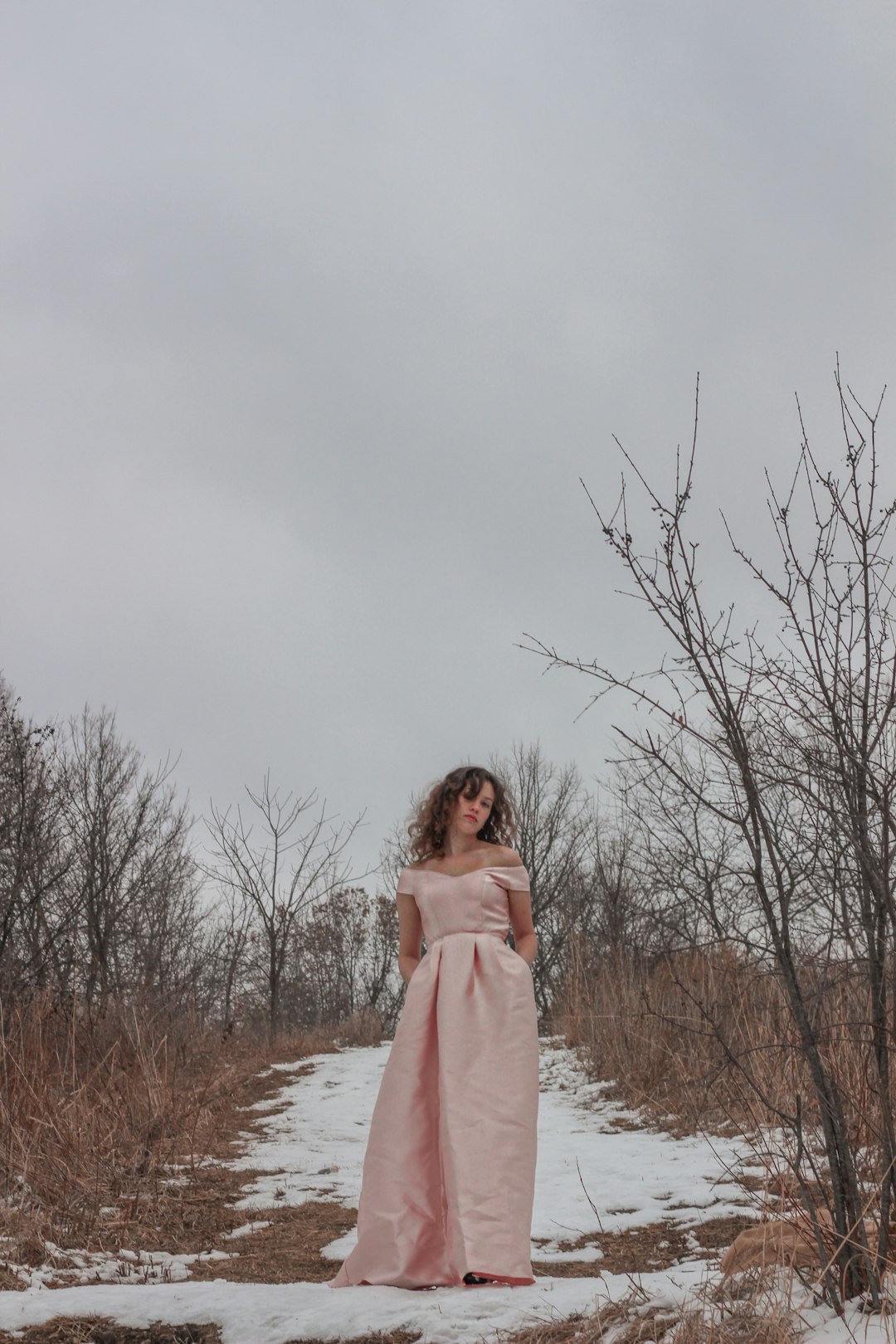 woman in pink long sleeve dress standing on snow covered ground