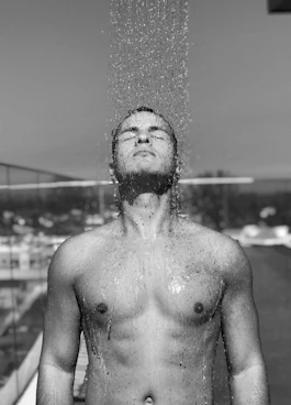 topless man with water droplets on his face