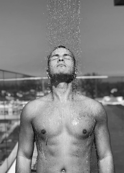 topless man with water droplets on his face