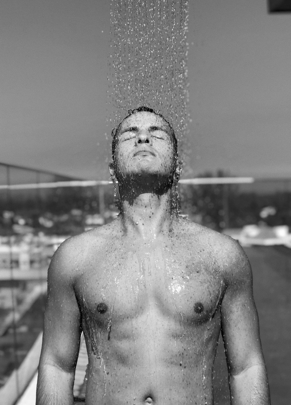 topless man with water droplets on his face