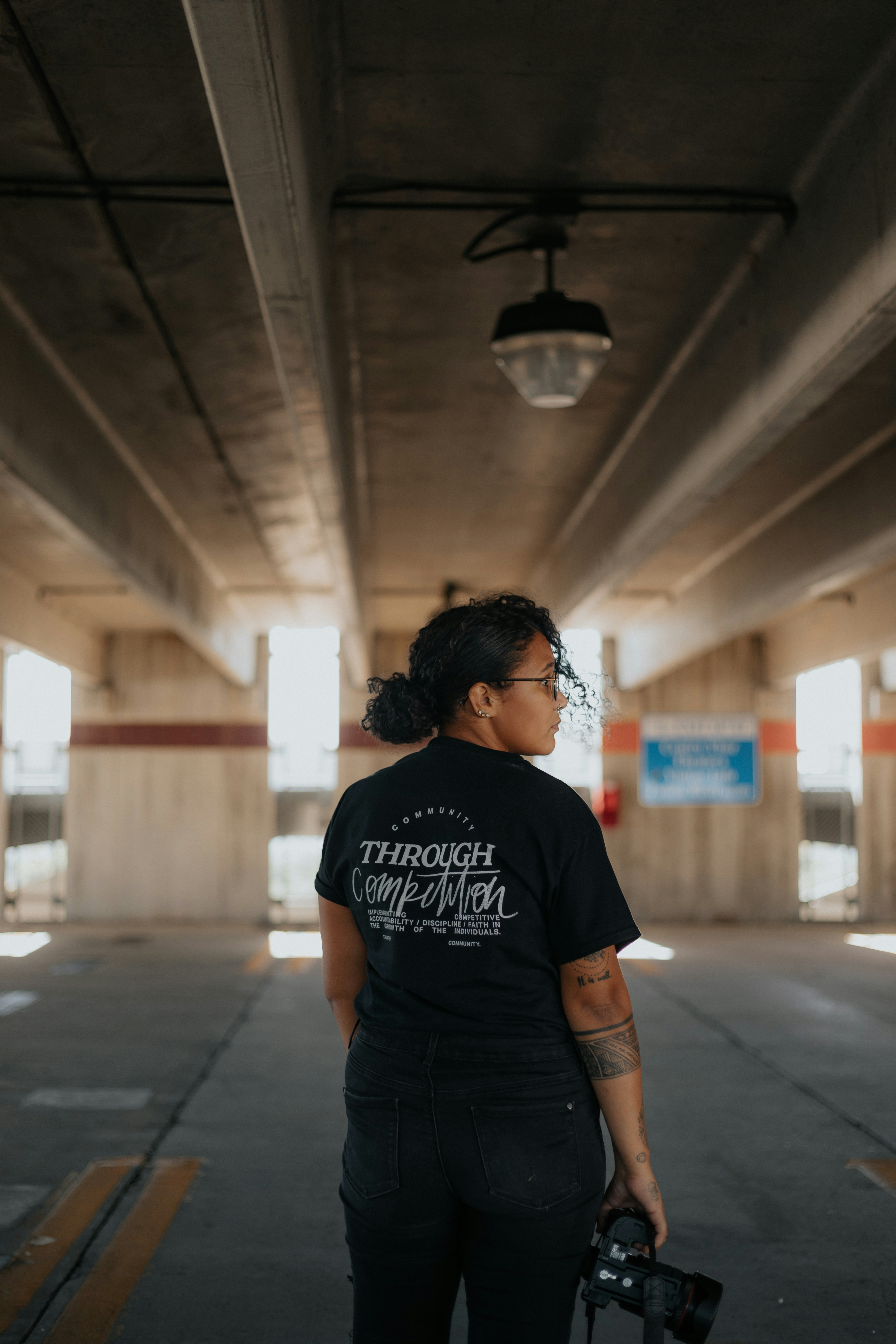 Femme en T-shirt à col rond noir debout sur le couloir