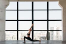 woman in black tank top and black leggings doing yoga
